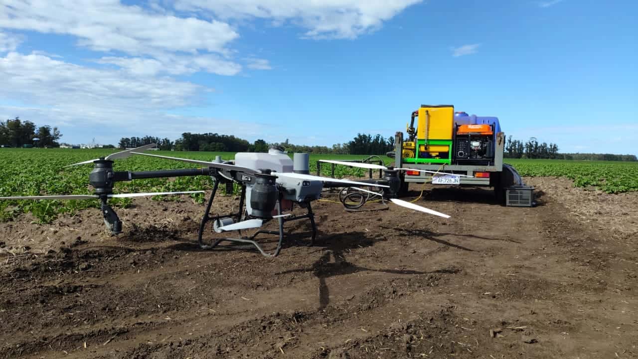 Drone agrícola apoyado en el lote de papa junto al camión de carga