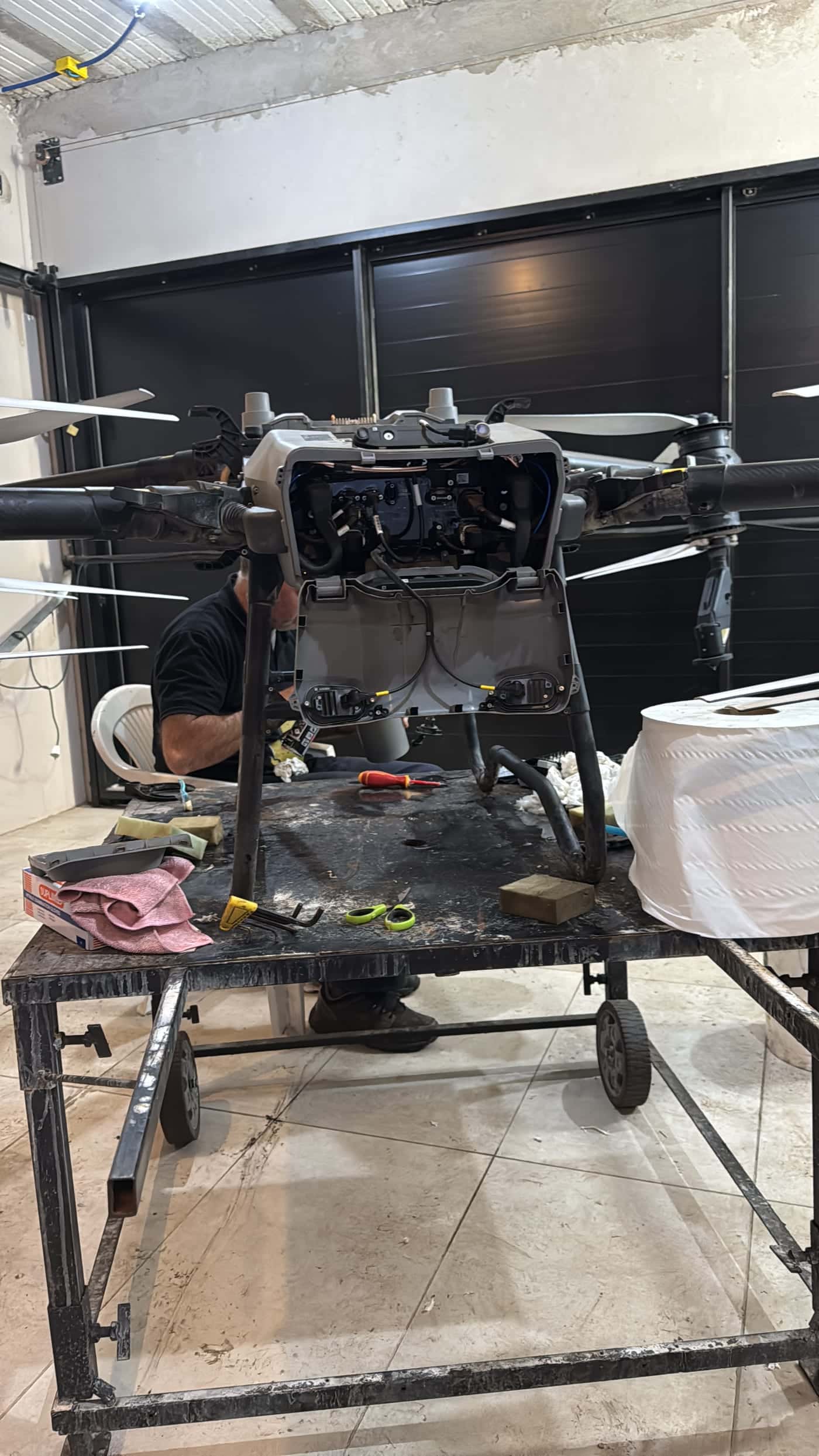 Drone agrícola abierto sobre la mesa del taller propio